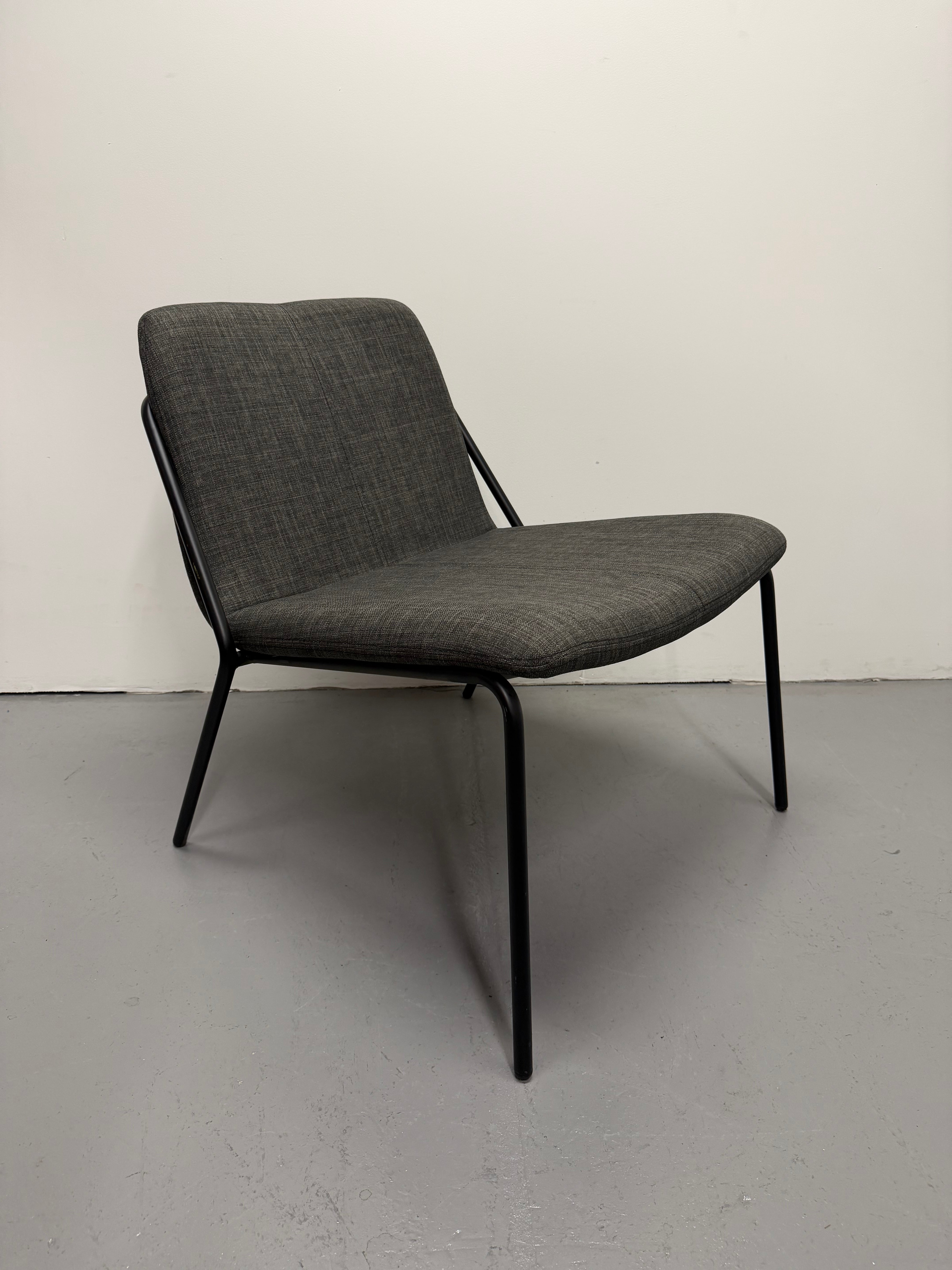 Gray upholstered chair with black metal frame on a plain background